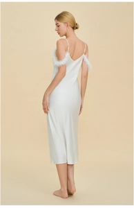 Détail de la chemise de nuit en satin blanc avec garniture en plumes et coupe ajustée