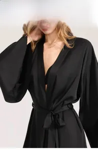 Detailed close-up of premium black matte satin robe showing silky fabric texture and V-neckline