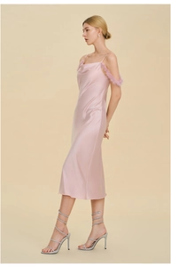 Détail d'une nuisette en satin rose avec d'élégantes bordures en plumes sur les bretelles