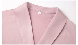 Close-up of silk satin bathrobe collar with size S tag in light pink luxury finish