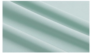 Detail of light mint green pajama fabric showing smooth texture and soft drape finish