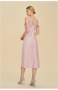 Gros plan sur la robe nuisette en satin rose avec plumes élégantes sur les bretelles
