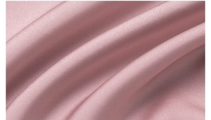 Close-up of pink luxury satin fabric showing elegant silk texture and smooth pearly luster