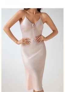 Detail shot of pink satin nightgown featuring a delicate front bow and thin straps