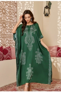 Close-up of dark green satin caftan with white paisley prints and elegant ethnic patterns