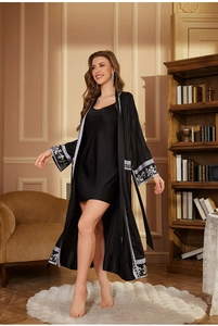 Détail d'un ensemble peignoir en satin noir de luxe avec motifs floraux argentés