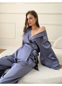 Détail d'un pyjama en satin bleu gris montrant la texture de la soie et la coupe fluide