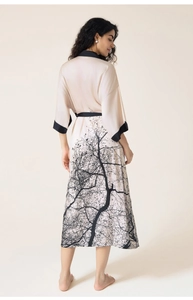 Detail of luxury champagne satin robe with black tree print and silk finish texture