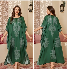 Detail view of emerald green satin kaftan with white ethnic mandala prints on front and back