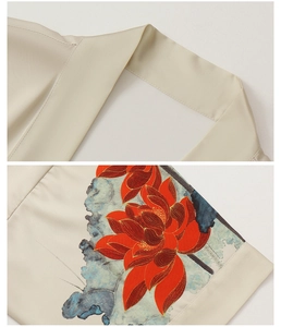 Detail of elegant satin bathrobe showing V-neckline and red lotus floral print