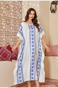 Detail of satin kaftan dress showing elegant blue ethnic floral print on white fabric