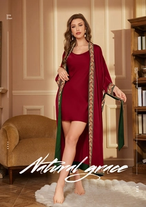 Close-up of elegant burgundy satin robe with vintage vine print edges and green lining