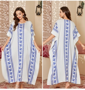 Front and back detail of a white floral kaftan dress with blue prints and long sleeves