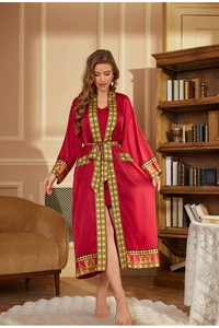 Détail du peignoir de luxe en satin rouge avec broderie dorée de style grec sur les bords