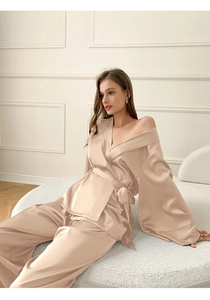 Détail d'un pyjama satiné champagne élégant avec texture soyeuse et ceinture à la taille