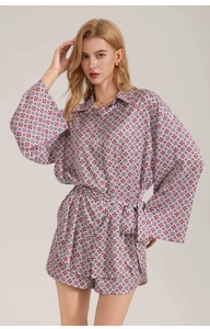 Detail of red and blue geometric print on long sleeve satin pajamas with a waist tie