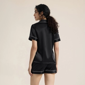Women's black satin pajama set with short sleeves and white piping trim back view