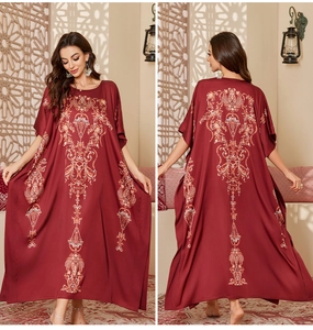 Detail of elegant satin kaftan with vintage gold patterns and a loose fit for women