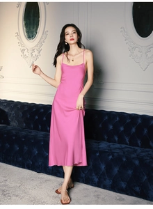 Détail de la texture d'une chemise de nuit en satin rose sur un canapé vintage