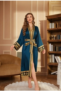 Détail du peignoir en soie sarcelle avec des motifs baroques dorés sur les poignets