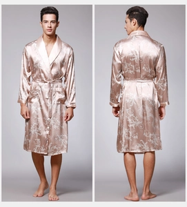 Detail view of champagne silk robe with intricate paisley patterns and matching waist tie