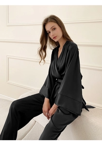 Détail d'un pyjama en satin noir montrant la texture soyeuse et la ceinture nouée