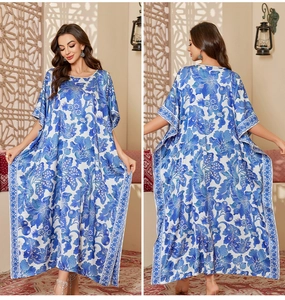 Detail of blue and white floral satin kaftan dress featuring loose fit and bohemian prints