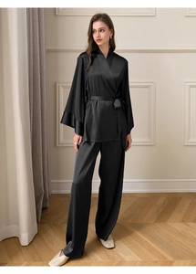 Détail d'un pyjama deux pièces en satin noir avec haut cache-cœur et pantalon large