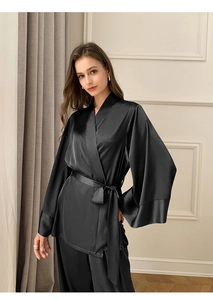 Détail d'un pyjama en satin noir avec haut kimono croisé et ceinture assortie