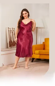 Close-up of wine red satin nightgown with cowl neck and silky texture on sofa