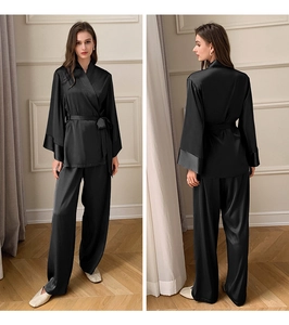 Détail de l'ensemble pyjama en satin noir avec haut noué et pantalon droit assorti