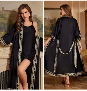 Detail of luxurious black satin robe set with ornate golden baroque patterned trim