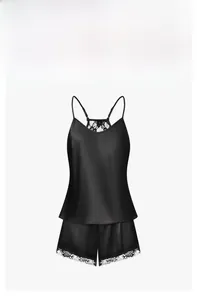 Close-up of black satin pajamas set with white lace trim on the shorts hem