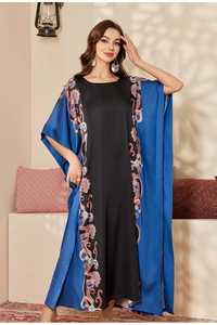 Close-up of luxurious satin kaftan dress with paisley print and silk-like finish