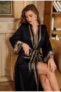 Détail d'un peignoir en soie noire avec bordure baroque et ceinture à la taille