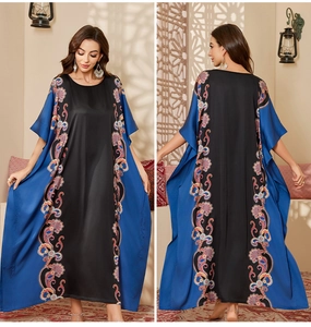 Detail of satin kaftan dress showing blue paisley patterns and loose batwing sleeve design