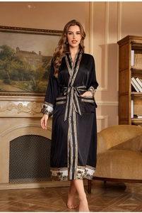 Détail d'un peignoir en satin noir avec motif baroque et ceinture élégante à nouer