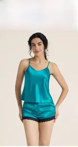 Detail view of teal silk pajama set with lace hem showing camisole and shorts