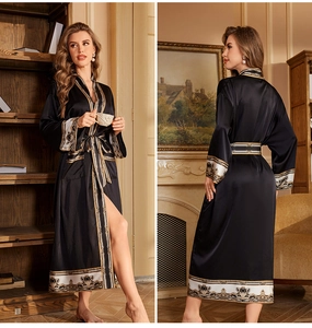 Détail d'un peignoir long en satin noir avec imprimé baroque sur les manches et l'ourlet