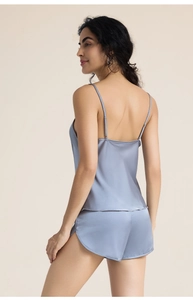 Détail d'un ensemble pyjama en satin avec fines bretelles et texture brillante bleu clair