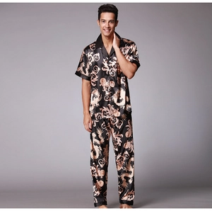 Detailed view of men's satin pajama set featuring golden dragon print on black fabric