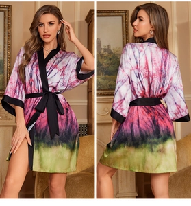 Detail view of satin floral bathrobe with green forest print and black trim front and back