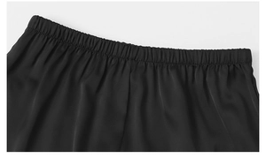 Détail de la taille élastique d'un pyjama en satin noir avec une texture soyeuse lisse