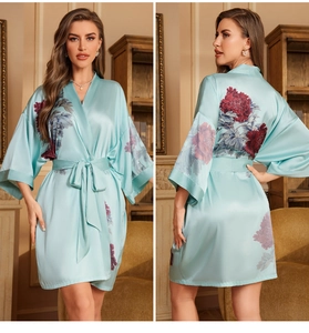 Detailed view of light blue satin bathrobe with vibrant pink peony floral patterns
