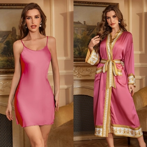 Détail d'un peignoir en satin rose avec motifs dorés et ensemble nuisette assortie