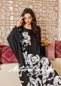 Detailed view of black satin kaftan featuring elegant white rose floral print patterns
