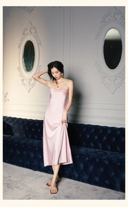 Détail d'une robe de nuit en satin rose avec fines bretelles et décolleté drapé élégant