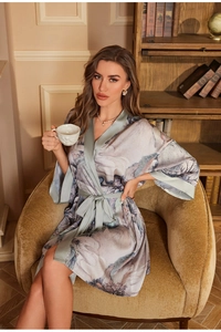 Detailed view of satin robe featuring landscape prints and contrasting green trim