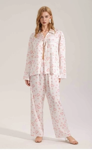 Detail of satin pajama set featuring a soft pink heart print on a white silk texture