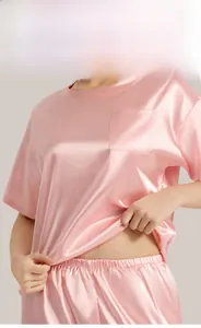 Detail of pink silk satin pajama set featuring chest pocket and premium smooth texture